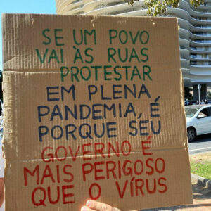 Foto de um cartaz escrito: "Se um povo vai às ruas protestar em plena pandemia, é porque seu governo é mais perigoso que o vírus"