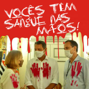 Foto do prefeito Rogério Santos, da secretária de Educação Cristina Barletta e do secretário de Saúde Adriano Catapreta. Os 3 estão com as camisas sujas de sangue e na parede está escrito: "VOCÊS TÊM SANGUE NAS MÃOS!"