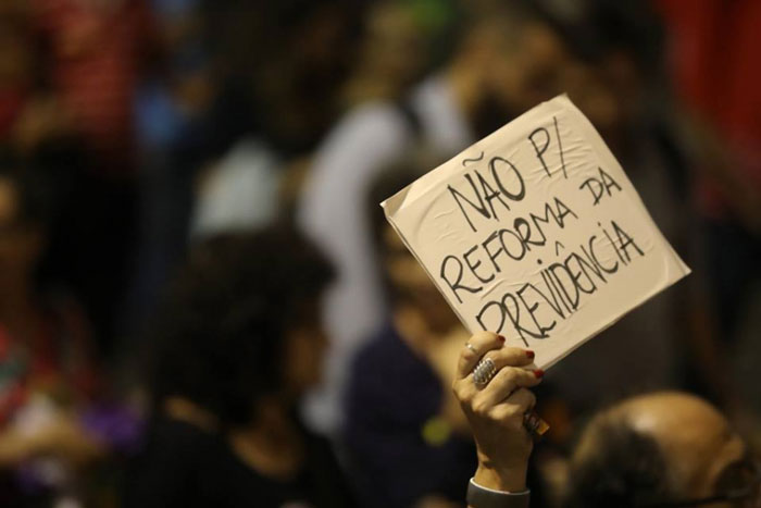 Foto de um ato com cartaz: "NÃO P/ REFORMA DA PREVIDÊNCIA"